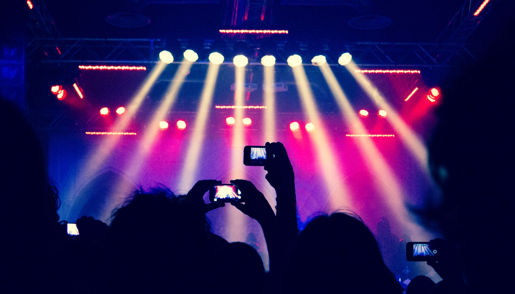 Hands filming a concert