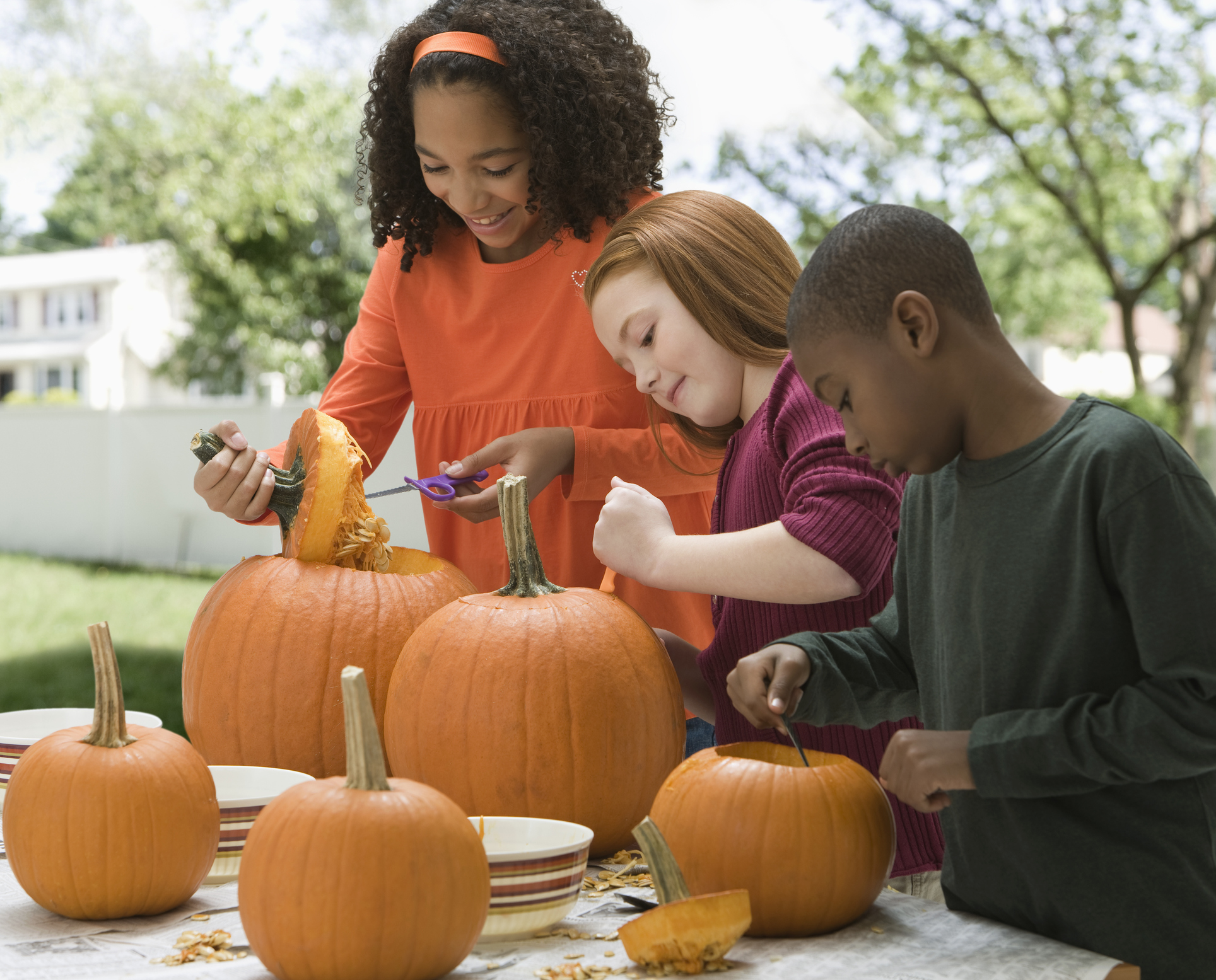Children carving Halloween pumpkins together