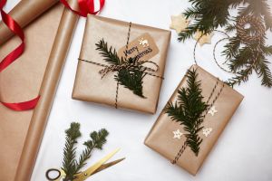 Christmas gifts wrapped in brown paper, decorated with fern and string, overhead view