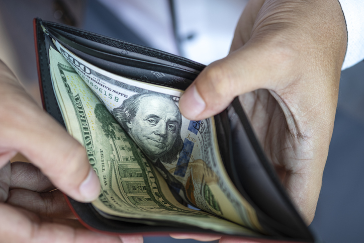 Midsection Of Man Holding Money In Wallet