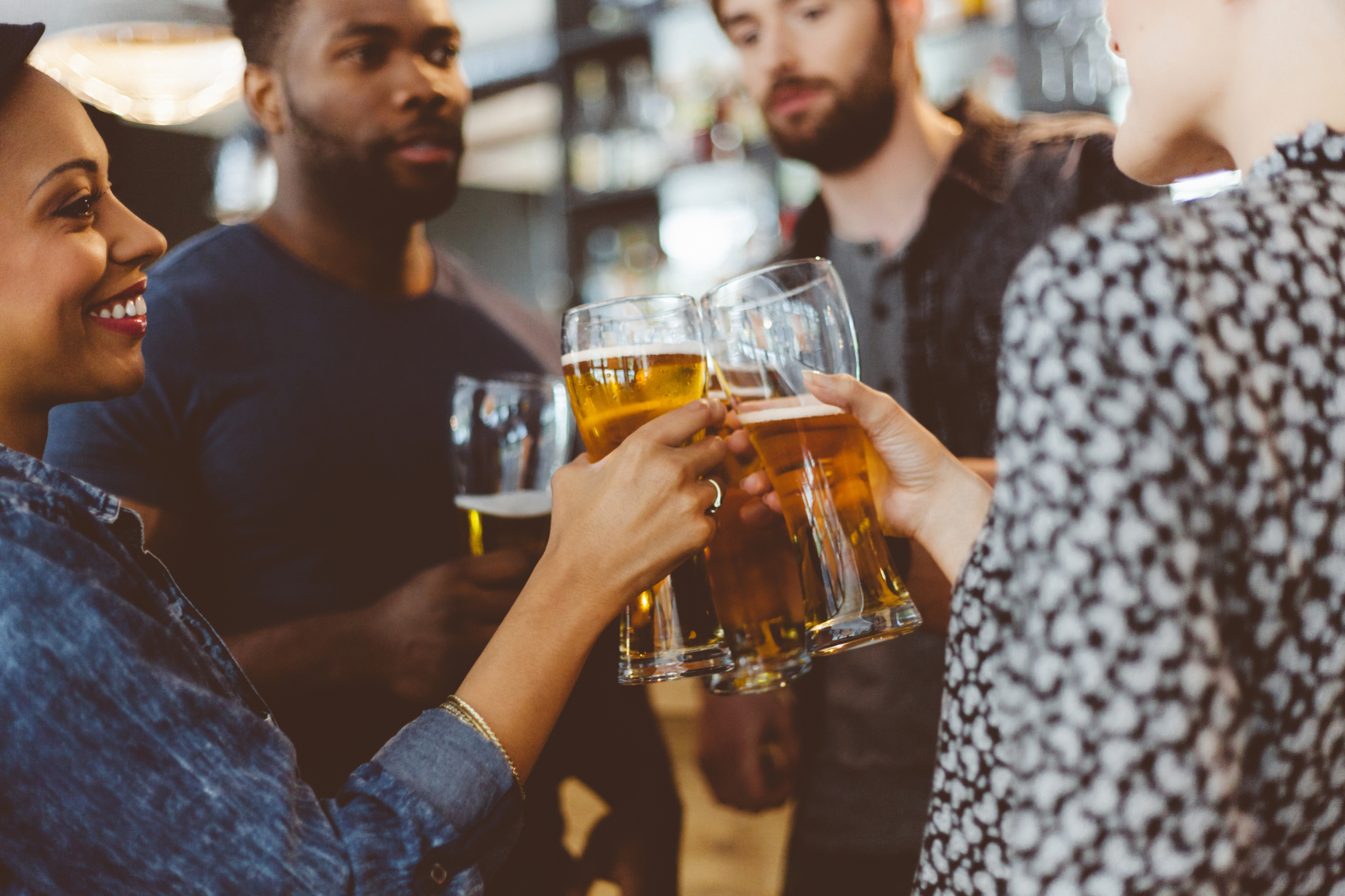 Friends toasting with beer in a pub