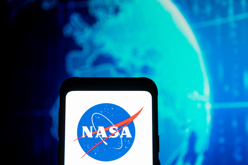 In this photo illustration a NASA logo seen displayed on a...