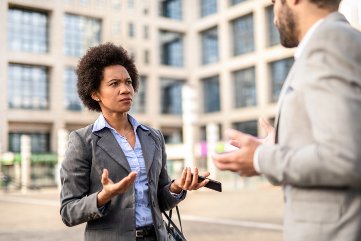 Serious businesswoman talking with a coworker.