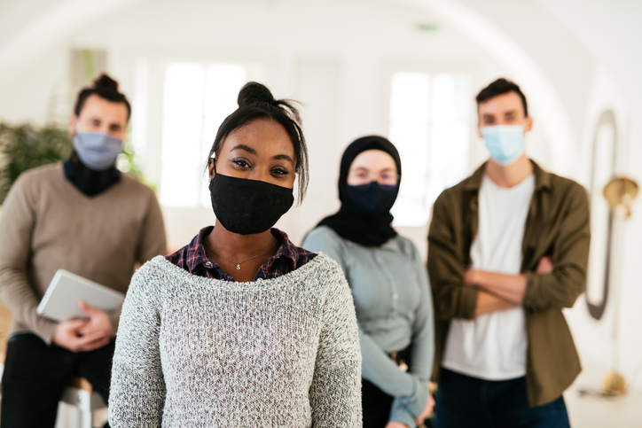 Employees posing in office with face masks