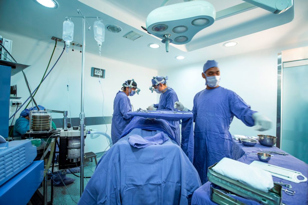 Teamwork of Surgeons, Surgical Instrumentalist, and Anesthesiologist working during surgical procedure.