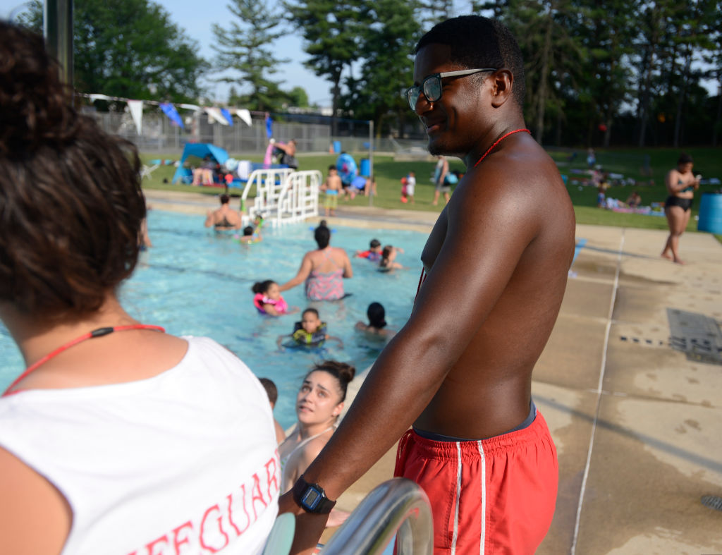 Arrindell pauses at one of the chairs to talk to a fellow lifeguard.Wensy Arrindell, a manager at Schlegel Park pool, helps the lifeguards keep hundreds of swimmers safe daily. Summer Jobs story. Photo by Jeremy Drey 6/30/2017