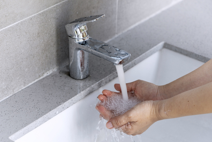 Hygiene concept: close up picture of lady washing her hands with detergent/soap in the toilet