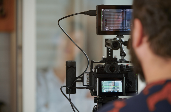 Professional video camera operator making film with businesswoman