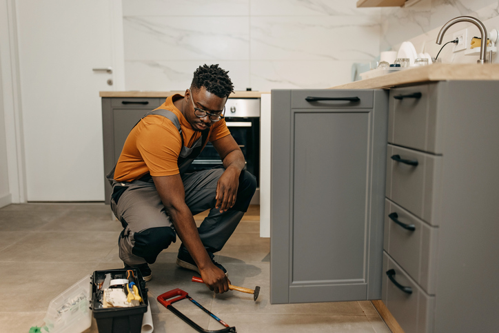 Plumber fixing kitchen sink
