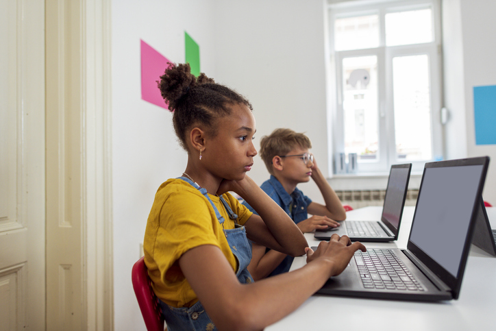 A diverse group of students in a STEM class using laptops