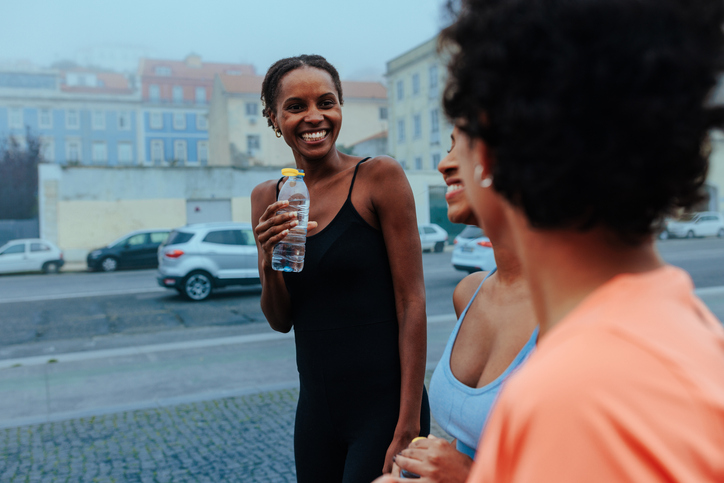 Group of smiling women drinking water after fitness training in Lisbon
